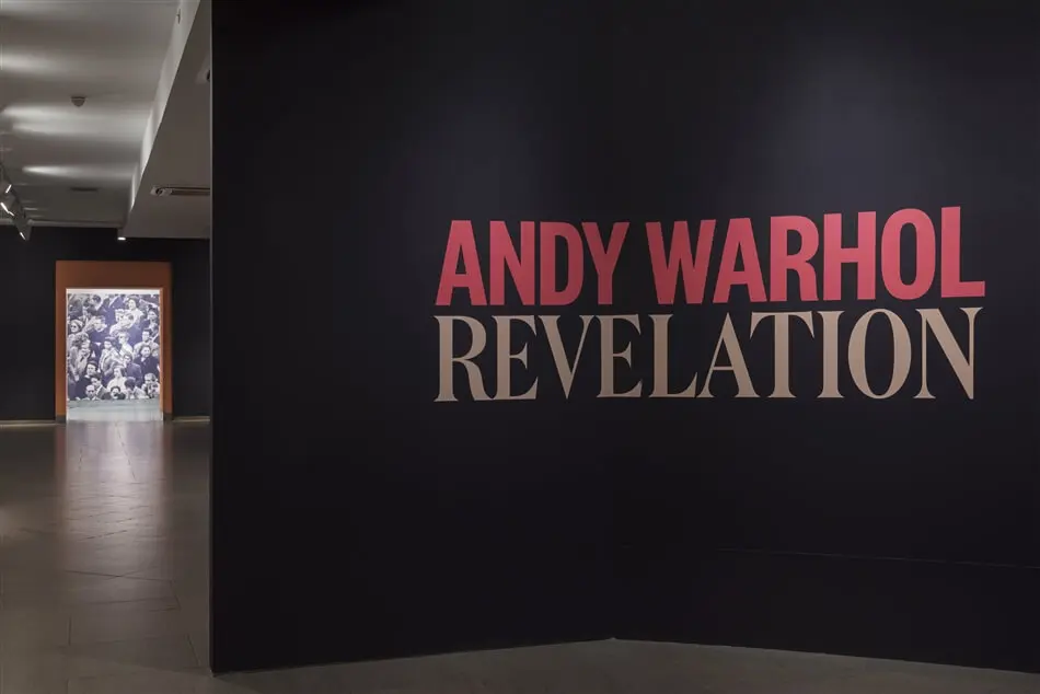A black wall with the words " andy warhol revelation ".