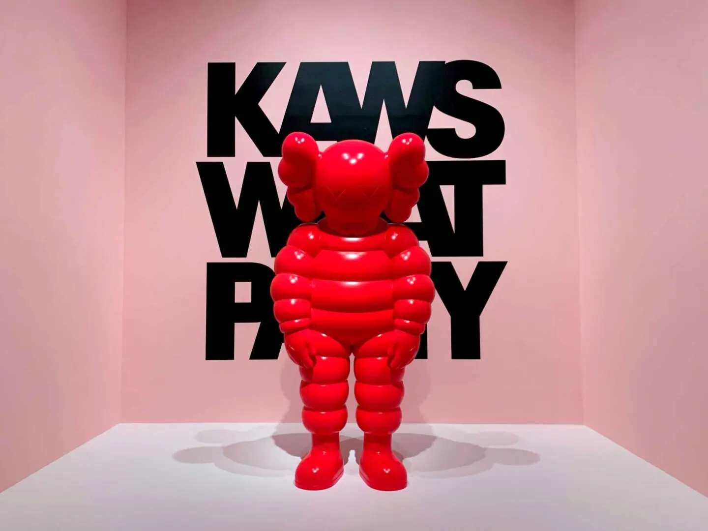 A red balloon bear is in front of the word " kws what party ".