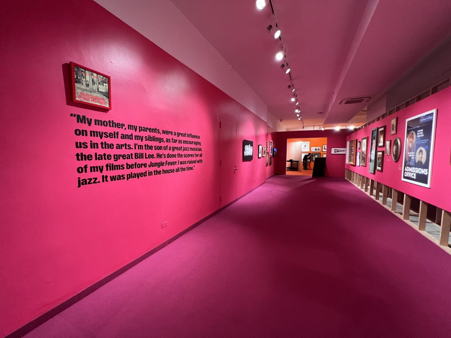 A hallway with pink walls and a wall quote.